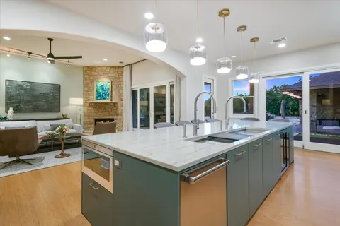 a kitchen with stainless steel appliances granite countertop a sink a stove and a refrigerator