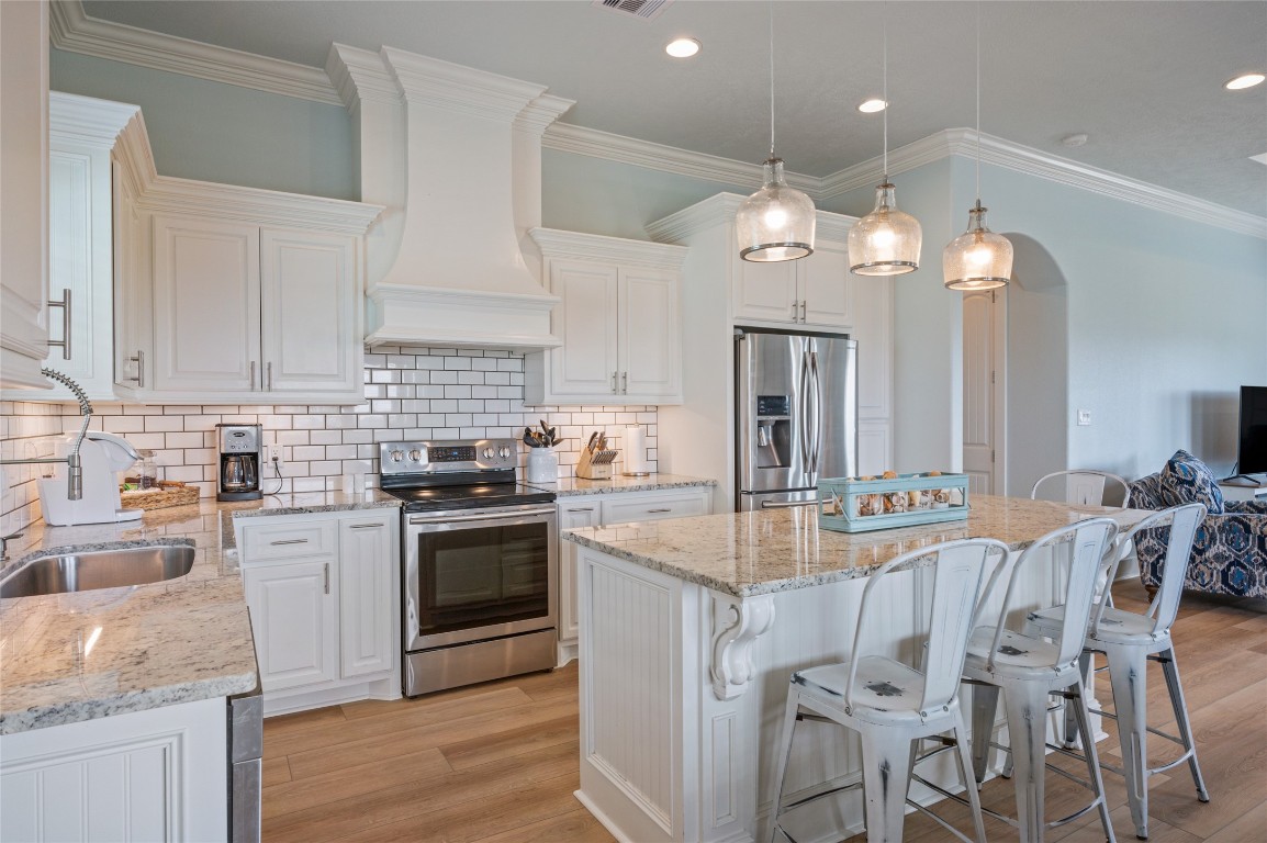 982 South Redfish Crystal Beach, TX 77650 - Photo 1 of 44 a kitchen with stainless steel appliances granite countertop a stove top oven a sink dishwasher a dining table and chairs with wooden floor