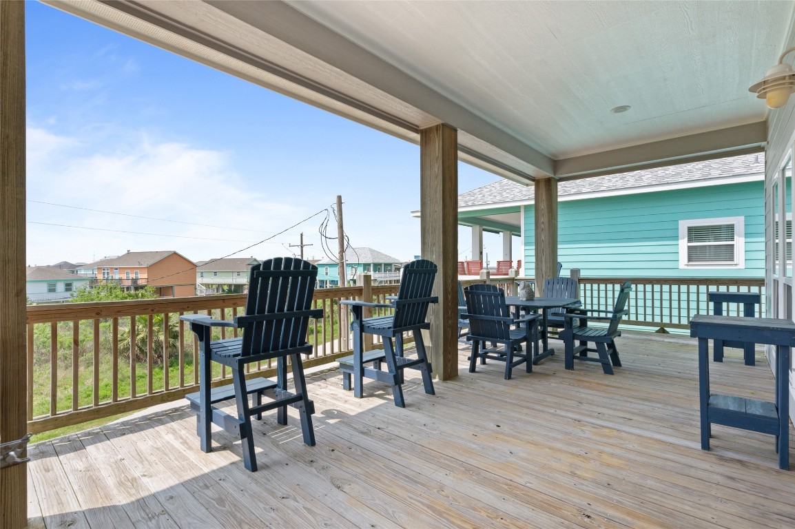 982 South Redfish Crystal Beach, TX 77650 - Photo 12 of 44 a view of a roof deck with table and chairs floor to ceiling window with wooden floor