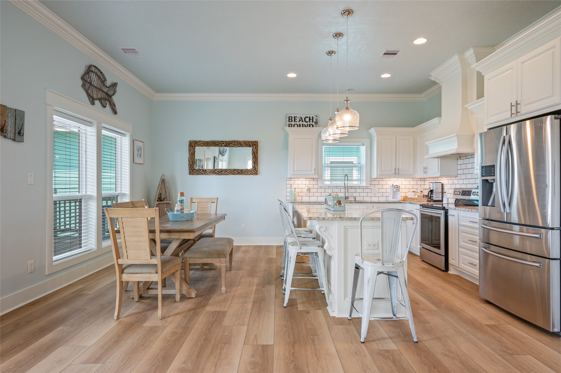 982 South Redfish Crystal Beach, TX 77650 - Photo 21 of 44 a dining room with stainless steel appliances a dining table chairs and wooden floor