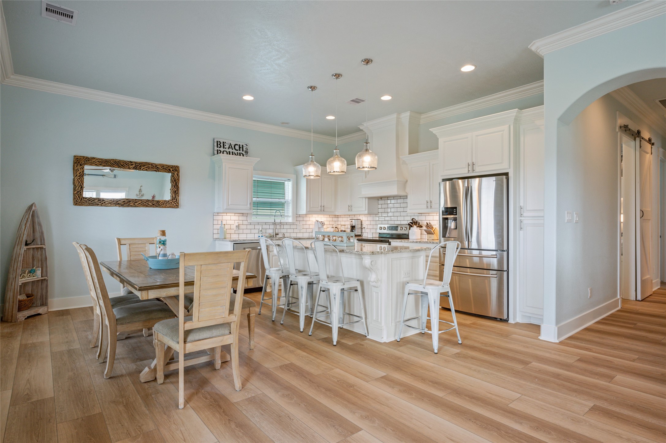 982 South Redfish Crystal Beach, TX 77650 - Photo 22 of 44 a dining room with furniture a wooden floor and a kitchen view