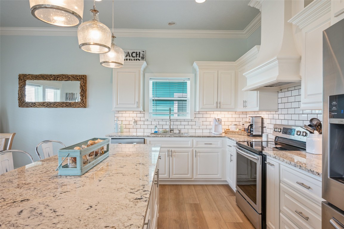 982 South Redfish Crystal Beach, TX 77650 - Photo 23 of 44 a kitchen with stainless steel appliances granite countertop a sink stove and refrigerator