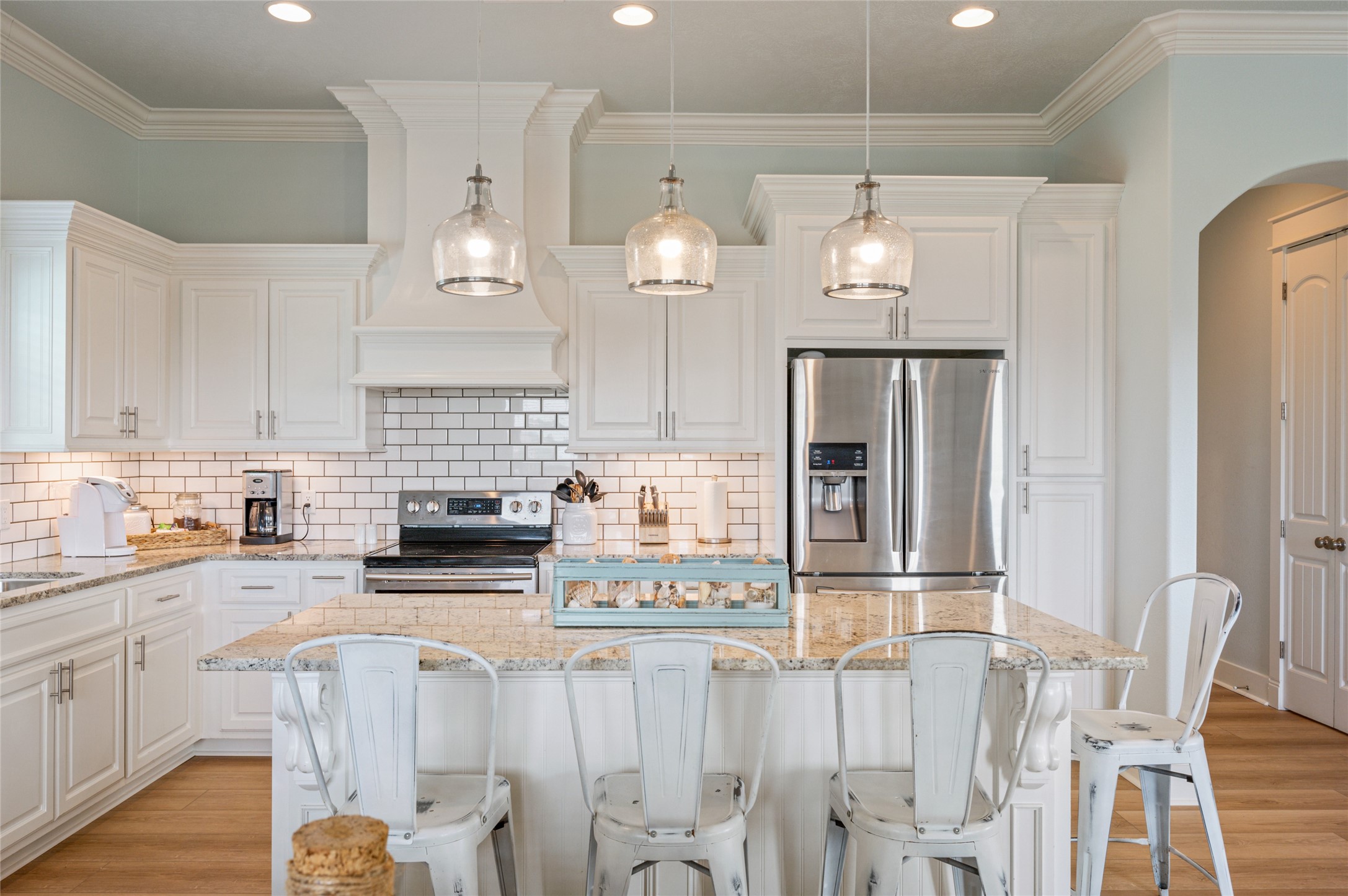 982 South Redfish Crystal Beach, TX 77650 - Photo 26 of 44 a kitchen with stainless steel appliances granite countertop a refrigerator a sink dishwasher a stove and white cabinets with wooden floor