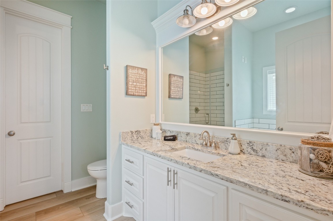 982 South Redfish Crystal Beach, TX 77650 - Photo 33 of 44 a bathroom with a granite countertop sink a toilet and a large mirror