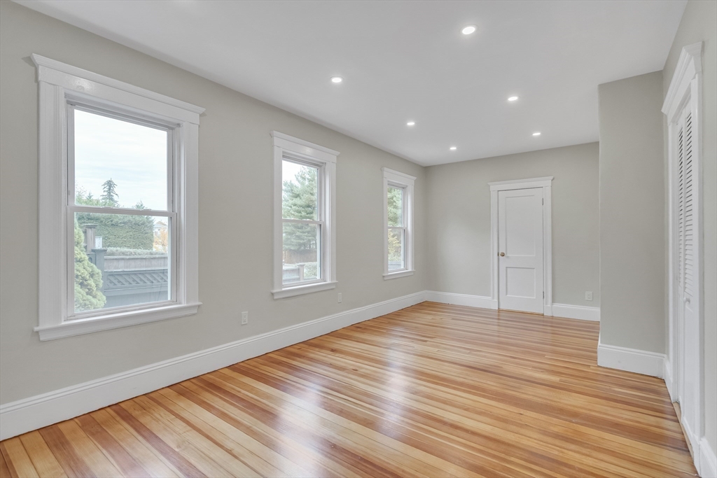 701 Hammond Street, Unit 1 Brookline, MA 02467 - Photo 12 of 28 a view of an empty room with wooden floor and a window