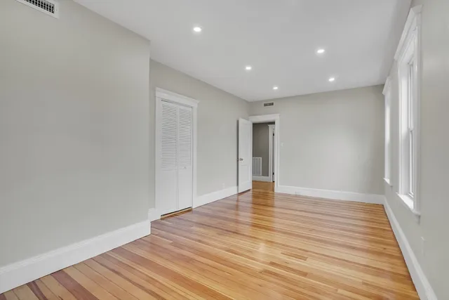 a view of an empty room with wooden floor