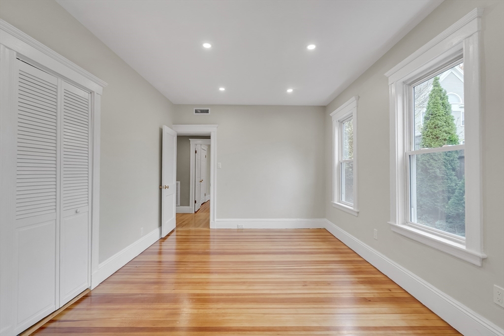 701 Hammond Street, Unit 1 Brookline, MA 02467 - Photo 14 of 28 a view of an empty room with wooden floor and a window