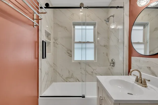 a bathroom with a sink a mirror and a shower