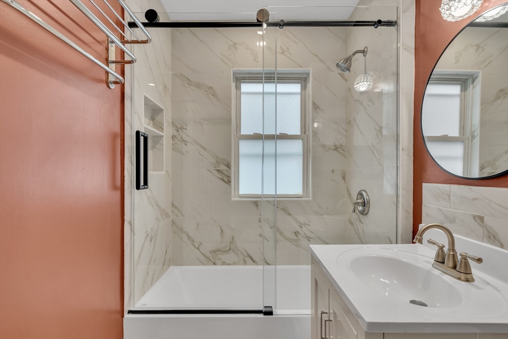 701 Hammond Street, Unit 1 Brookline, MA 02467 - Photo 17 of 28 a bathroom with a sink a mirror and a shower