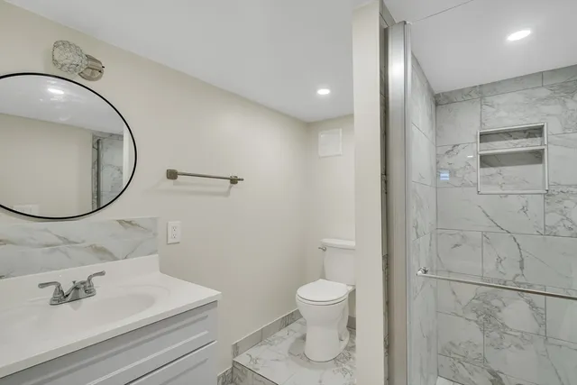 a bathroom with a sink a toilet and a mirror