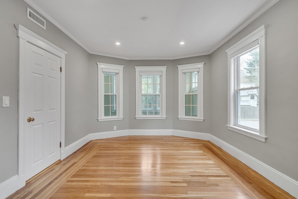701 Hammond Street, Unit 1 Brookline, MA 02467 - Photo 3 of 28 a view of empty room with wooden floor and fan