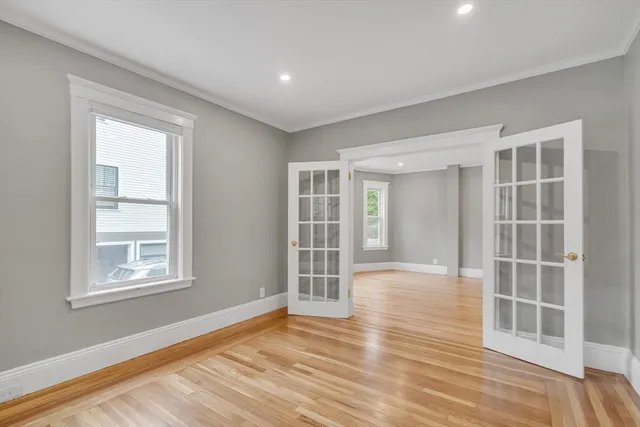 an empty room with wooden floor and windows