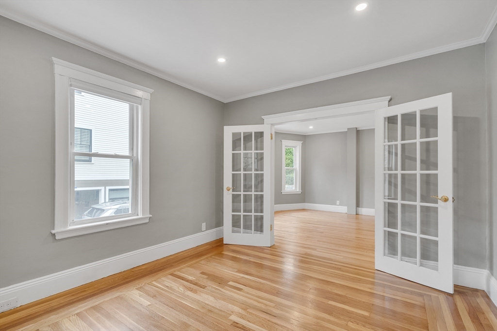 701 Hammond Street, Unit 1 Brookline, MA 02467 - Photo 4 of 28 an empty room with wooden floor and windows