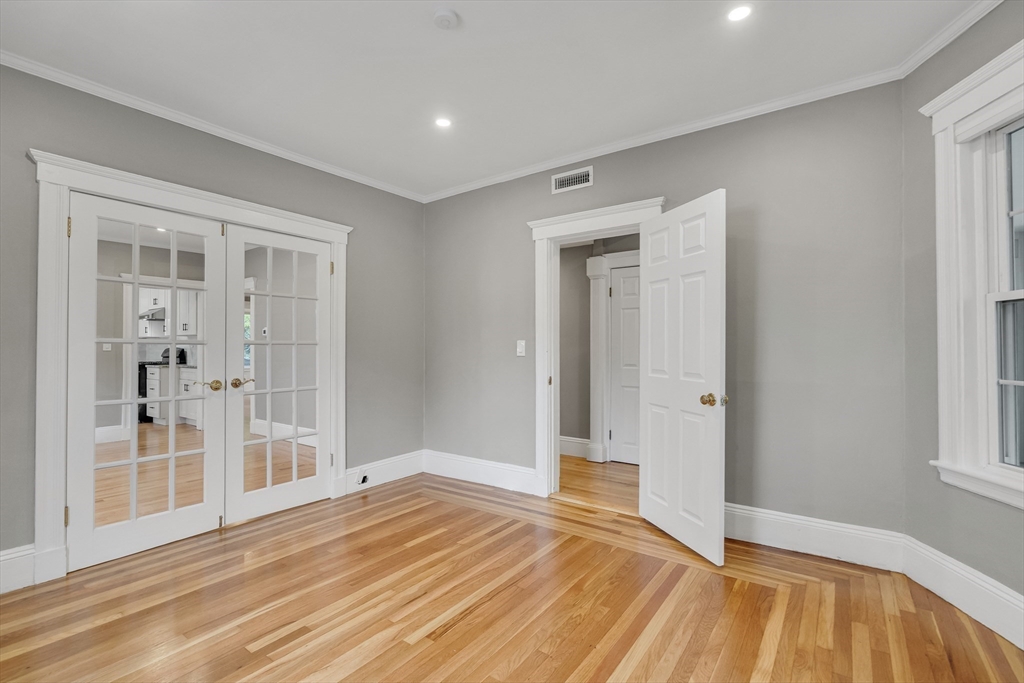 701 Hammond Street, Unit 1 Brookline, MA 02467 - Photo 5 of 28 a view of a room with wooden floor and a bathroom