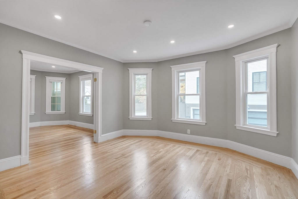 701 Hammond Street, Unit 1 Brookline, MA 02467 - Photo 6 of 28 a view of an empty room with wooden floor and window