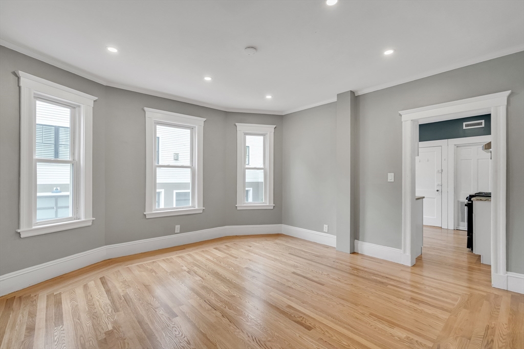 701 Hammond Street, Unit 1 Brookline, MA 02467 - Photo 7 of 28 a view of empty room with wooden floor and fan