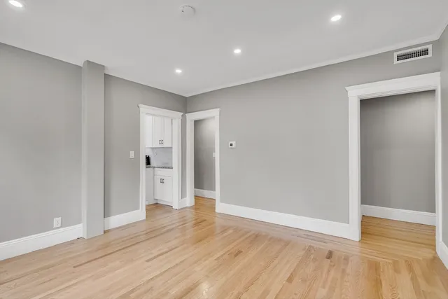 a view of empty room with wooden floor