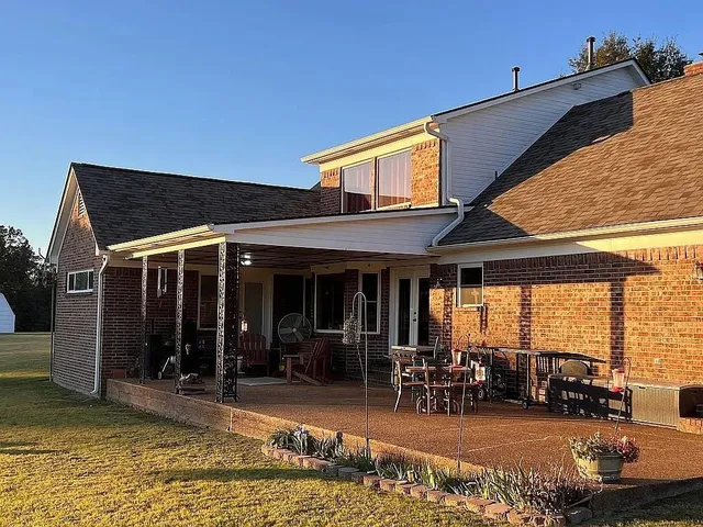 a view of a house with floor to ceiling windows and dining table