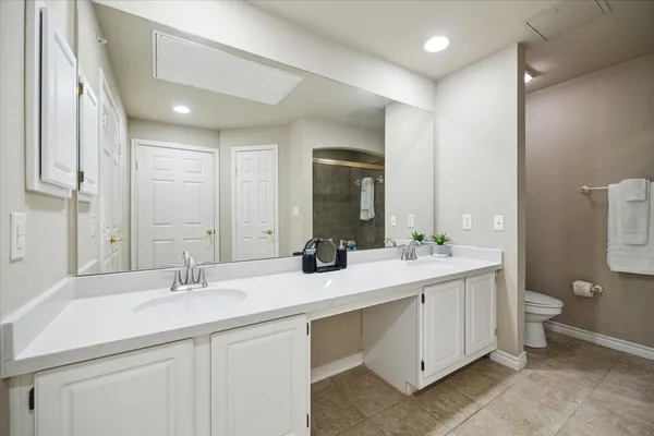 a bathroom with a double vanity sink mirror and toilet