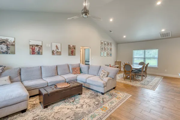 a living room with furniture and view of kitchen