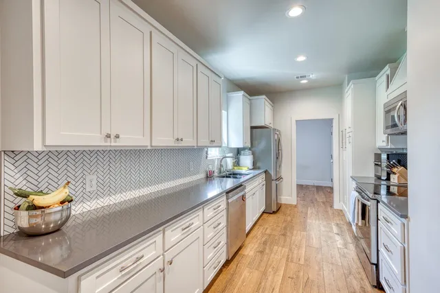 a kitchen with stainless steel appliances granite countertop a refrigerator and a sink