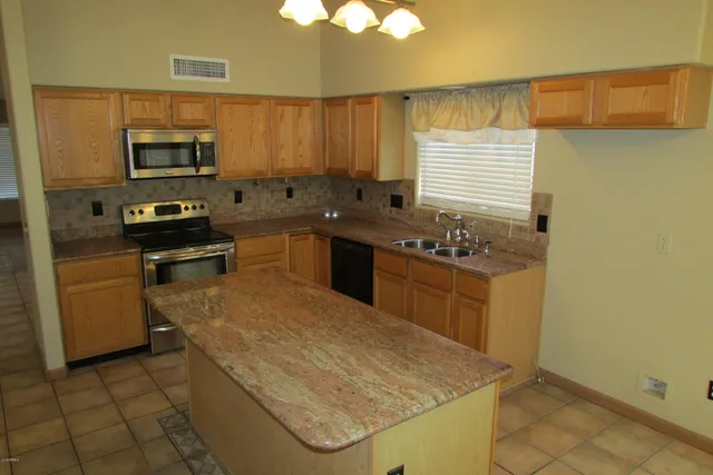 a kitchen with stainless steel appliances granite countertop a sink stove and microwave