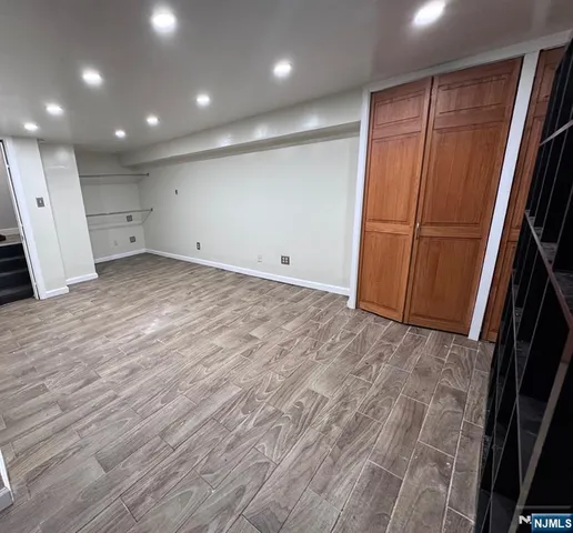 an empty room with wooden floor and cabinet