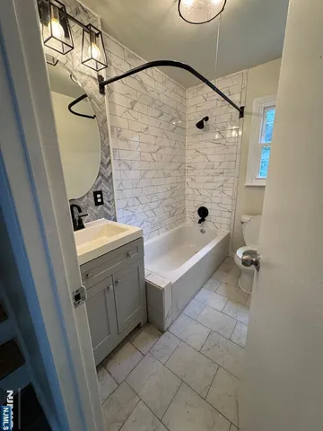 a bathroom with a granite countertop sink a toilet and shower