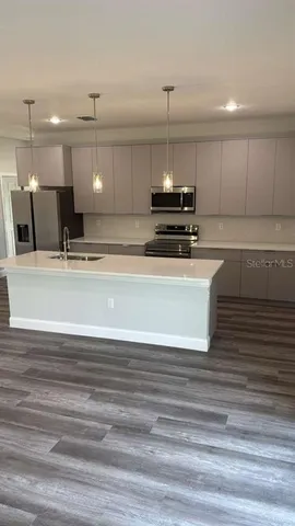 a view of kitchen with kitchen island a sink and a stove