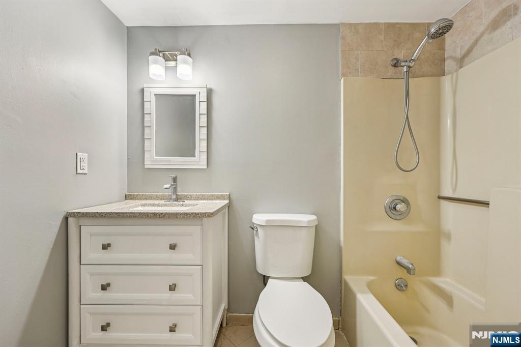 105 State Street, Unit 1H Hackensack, NJ 07601 - Photo 15 of 23 a bathroom with a granite countertop sink toilet and shower