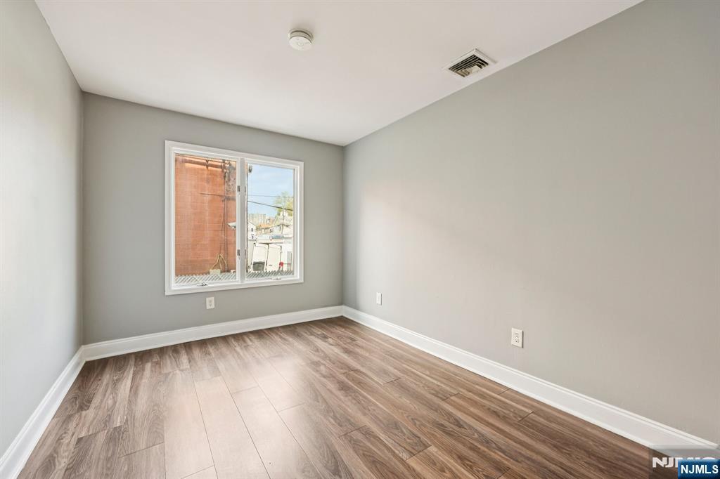 105 State Street, Unit 1H Hackensack, NJ 07601 - Photo 22 of 23 a view of an empty room with wooden floor and a window