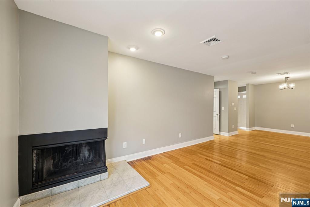 105 State Street, Unit 1H Hackensack, NJ 07601 - Photo 5 of 23 a view of empty room with wooden floor and fireplace