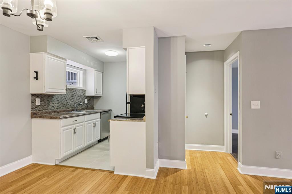 105 State Street, Unit 1H Hackensack, NJ 07601 - Photo 8 of 23 a kitchen with granite countertop white cabinets and white appliances