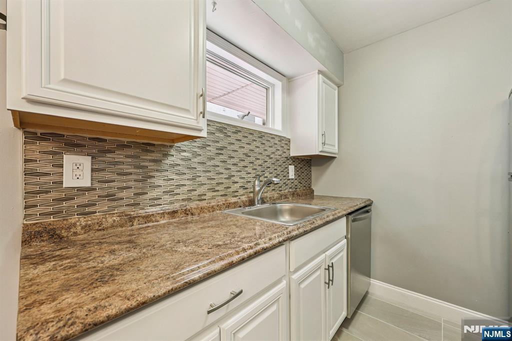 105 State Street, Unit 1H Hackensack, NJ 07601 - Photo 9 of 23 a bathroom with a granite countertop sink and a mirror