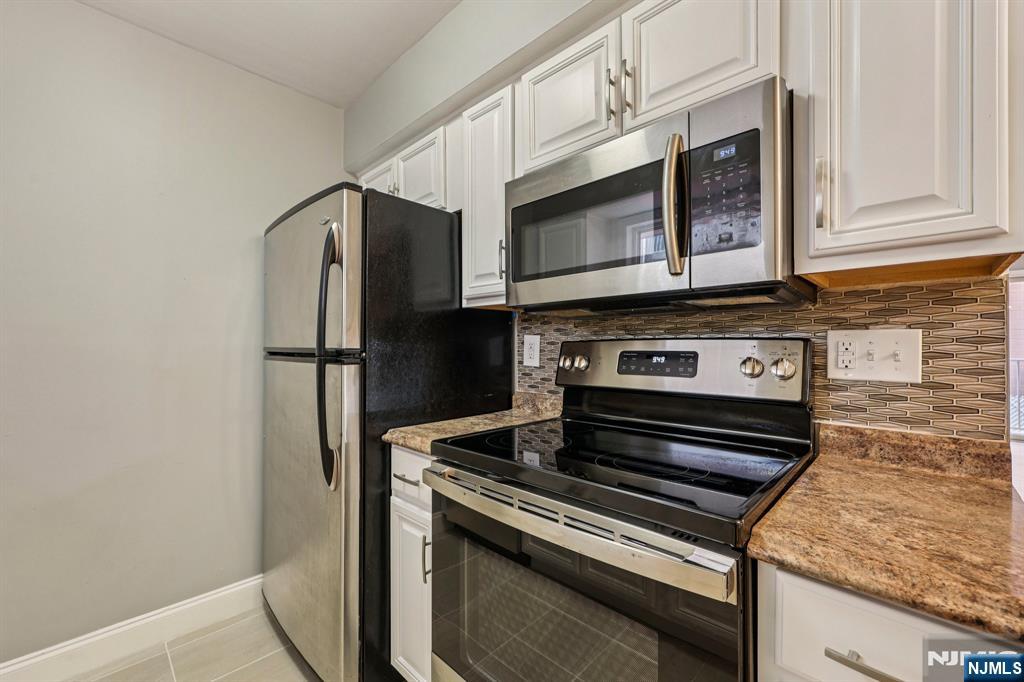 105 State Street, Unit 1H Hackensack, NJ 07601 - Photo 10 of 23 a kitchen with stainless steel appliances granite countertop a stove microwave and refrigerator