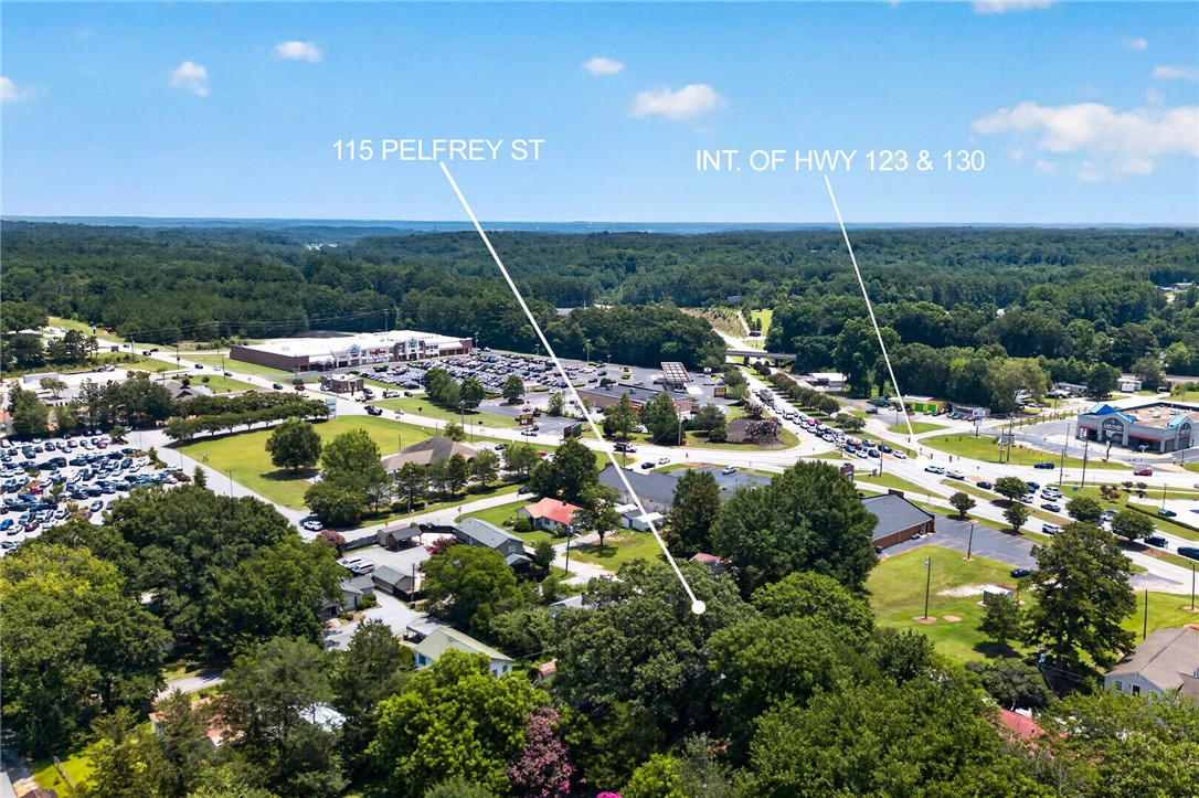 115 Pelfrey Street Seneca, SC 29672 - Photo 45 of 46 An aerial perspective reveals a vibrant neighborhood bordered by a bustling commercial center and verdant forests.