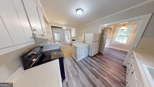a view of a kitchen with furniture and wooden floor
