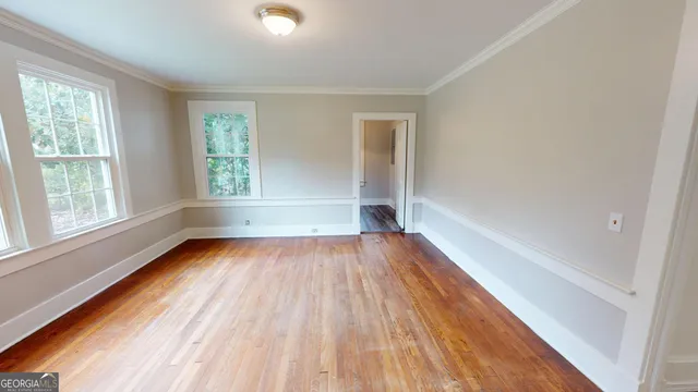 a view of wooden floor in an empty room with a window