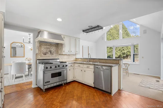 a kitchen with stainless steel appliances granite countertop a stove and a white cabinets