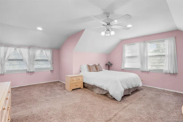 a spacious bedroom with a large bed and a chandelier