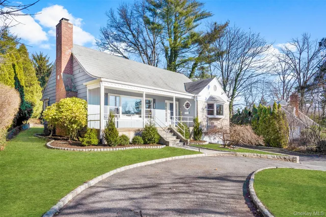 a front view of a house with a yard and potted plants