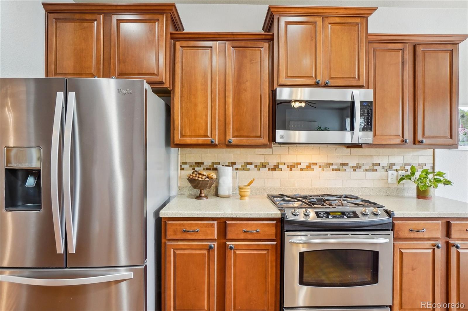 2605 Gray Wolf Loop Broomfield, CO 80023 - Photo 15 of 49 a kitchen with granite countertop a refrigerator stove and microwave