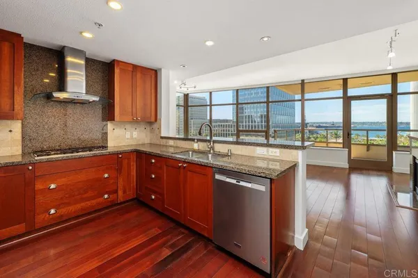 a kitchen with stainless steel appliances granite countertop a sink stove and wooden cabinets