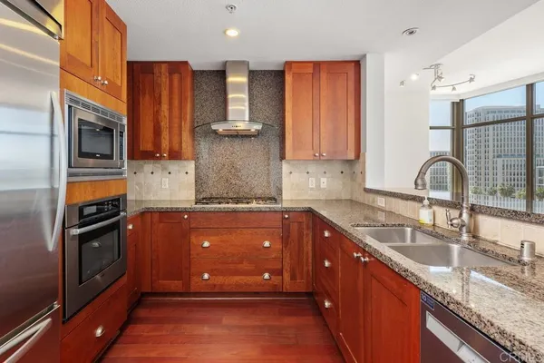 a kitchen with stainless steel appliances granite countertop a sink stove and refrigerator