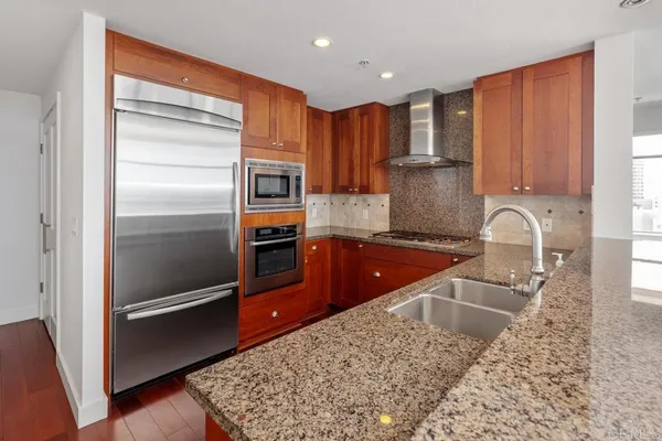 a kitchen with stainless steel appliances granite countertop a refrigerator and a sink