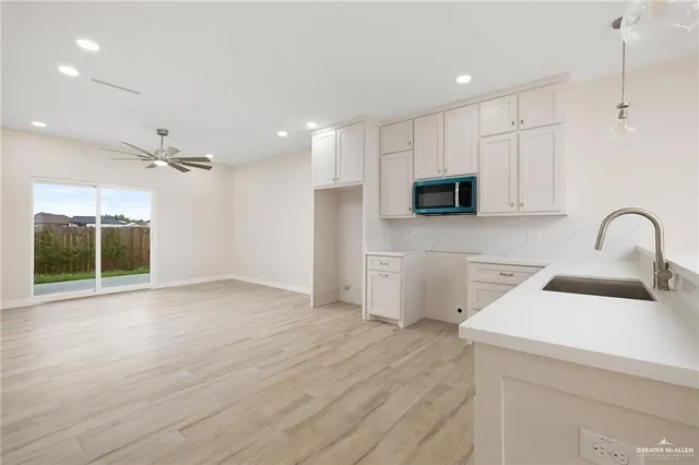 a view of a kitchen with a sink and dishwasher with wooden floor