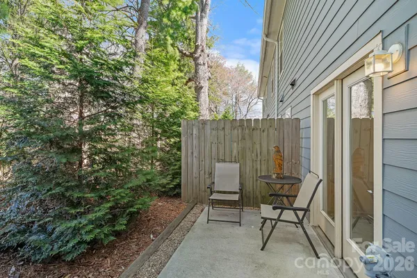 a view of a patio with table and chairs and potted plants with wooden fence
