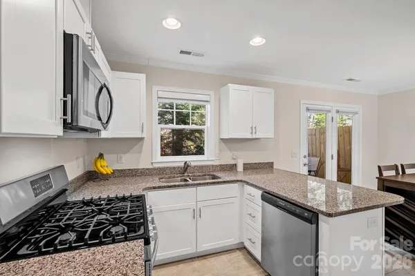 a kitchen with stainless steel appliances granite countertop a stove and a sink