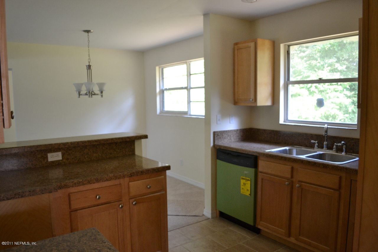 7003 Clovis Road Jacksonville, FL 32205 - Photo 3 of 10 a kitchen with a sink and wooden cabinets