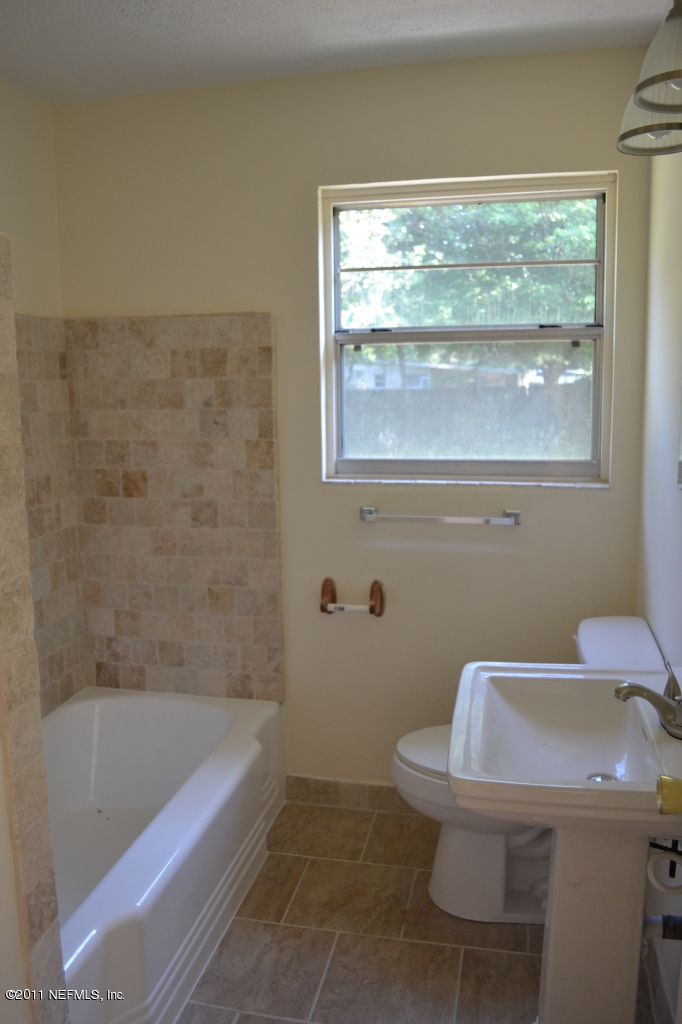 7003 Clovis Road Jacksonville, FL 32205 - Photo 4 of 10 a bathroom with a sink a toilet and bathtub